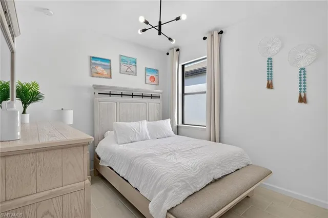 a bedroom with a large bed and a potted plant