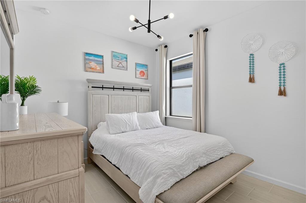 1953 Fresno Avenue Naples, FL 34120 - Photo 15 of 33 a bedroom with a large bed and a potted plant