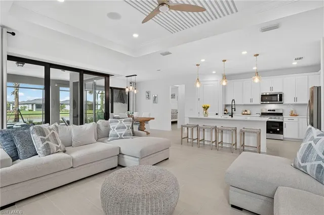 a living room with furniture kitchen and a large window