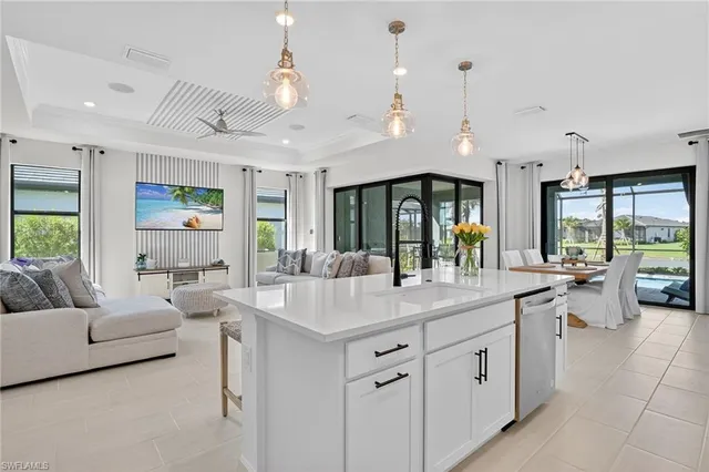 a dining hall with stainless steel appliances kitchen island granite countertop a stove a sink a dining table and chairs with wooden floor