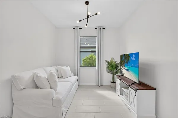 a living room with furniture a flat screen tv and a window