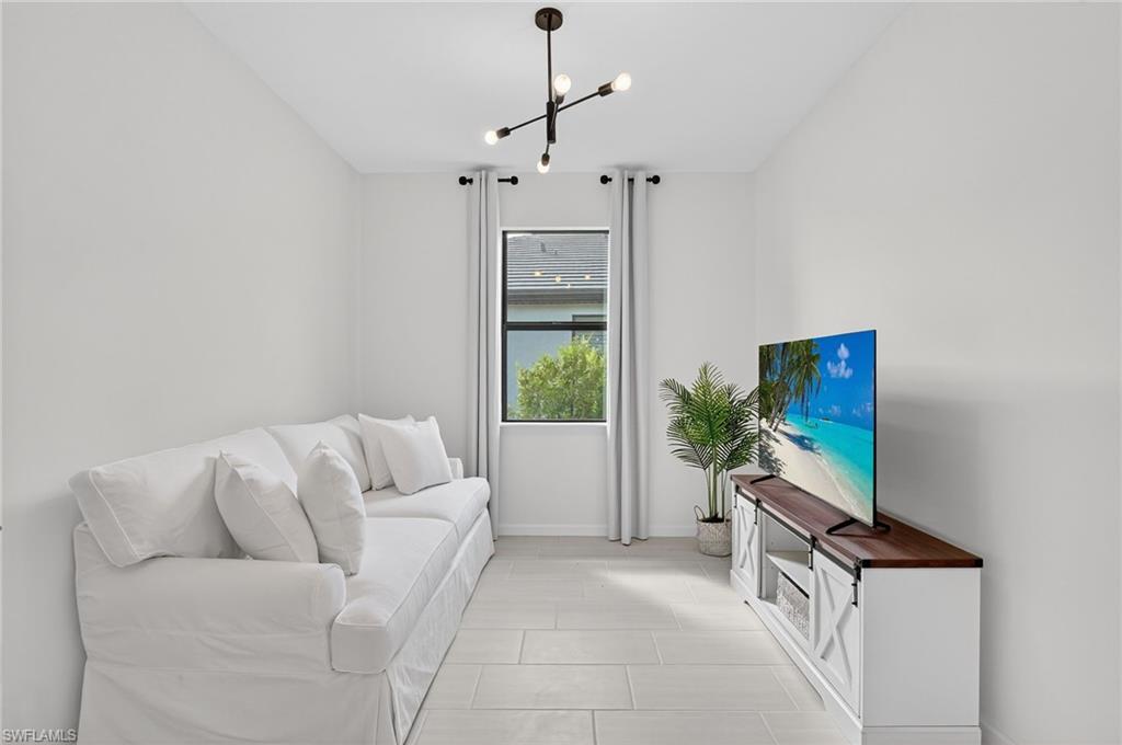 1953 Fresno Avenue Naples, FL 34120 - Photo 8 of 33 a living room with furniture a flat screen tv and a window