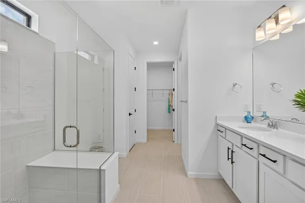 a spacious bathroom with a double vanity sink a large mirror and a shower