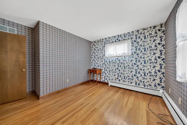 a view of an empty room with wooden floor