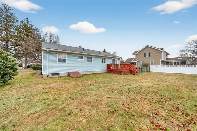 a front view of house with yard and trees in the background
