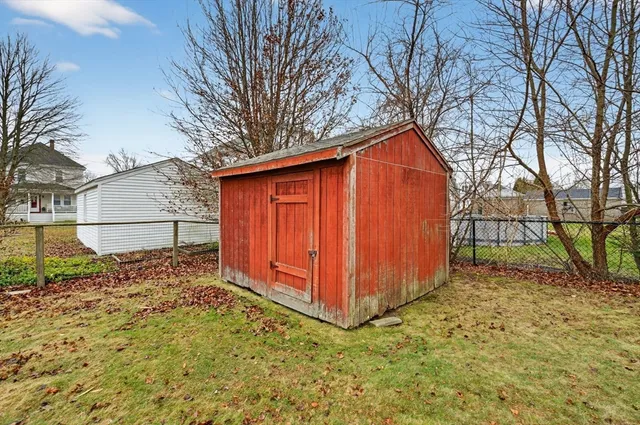 a backyard of a house with wooden fence and large trees