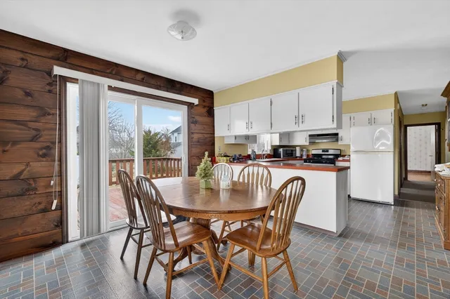 a kitchen with stainless steel appliances granite countertop a stove a refrigerator a kitchen island and chairs in it