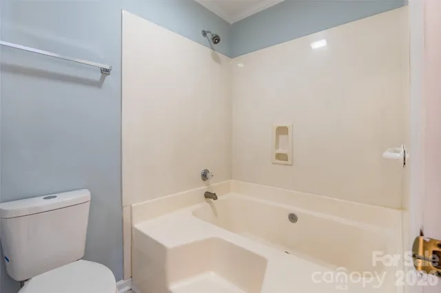 a white bath tub sitting next to a white toilet and sink