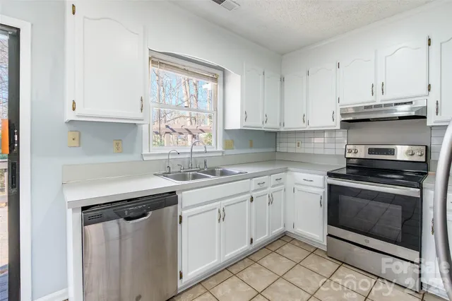 a kitchen with stainless steel appliances granite countertop a sink stove and cabinets