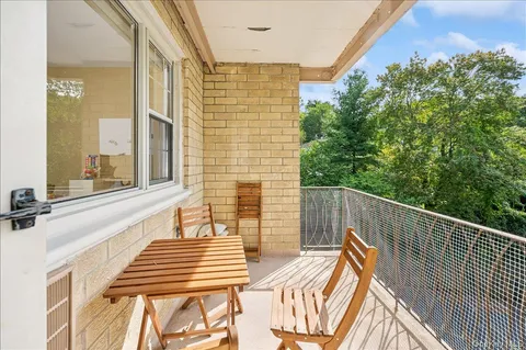 a view of a balcony with wooden floor and outdoor seating