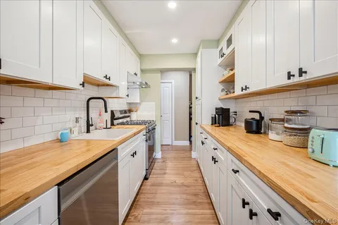 a large kitchen with stainless steel appliances granite countertop a sink and cabinets