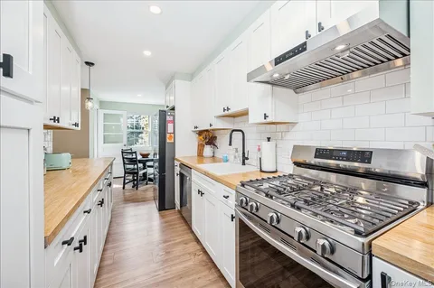 a large kitchen with a stove and white cabinets