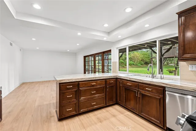 a kitchen with stainless steel appliances granite countertop a sink and wooden cabinets