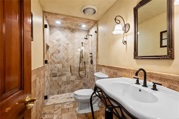 a bathroom with a sink a toilet and shower