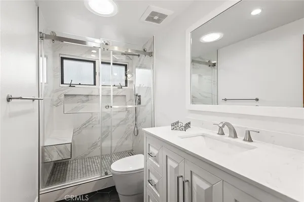 a bathroom with a granite countertop sink toilet and shower