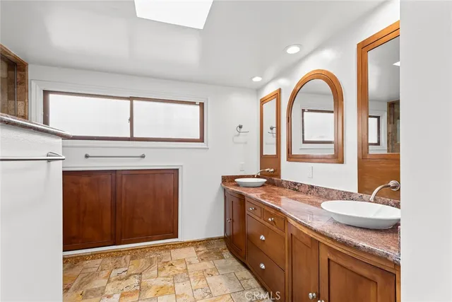 a bathroom with a granite countertop sink a mirror and a shower