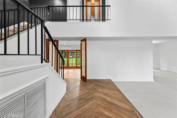 a view of a hallway with wooden floor and staircase