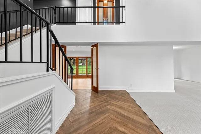a view of a hallway with wooden floor and staircase