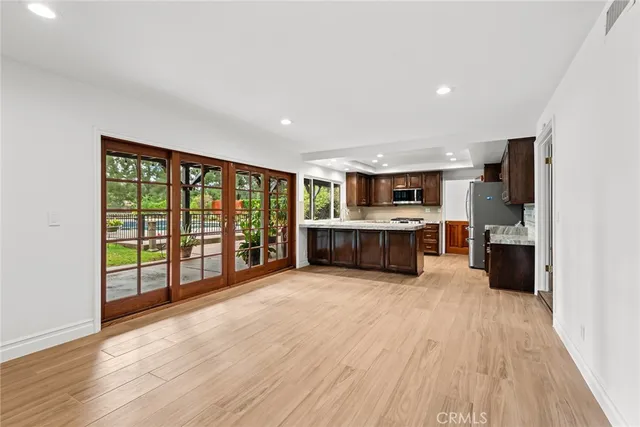 a large kitchen with stainless steel appliances granite countertop a large center island and a wooden floors