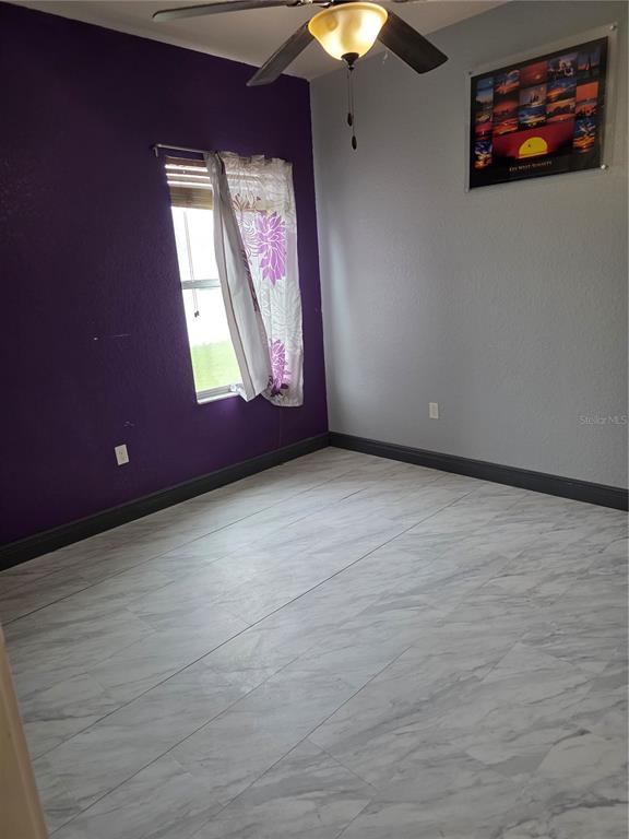 2850 Sheldon Street Lakeland, FL 33813 - Photo 31 of 59 an empty room with windows and chandelier fan