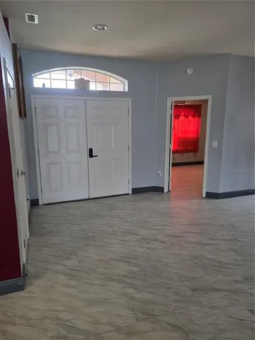 an empty room with windows and fireplace