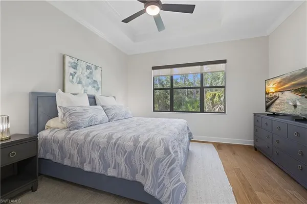 a bedroom with a bed and a flat tv screen on dresser
