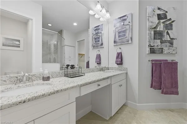 a bathroom with a granite countertop double vanity sink and a mirror