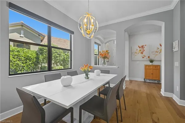 a view of a dining room with furniture a chandelier and wooden floor