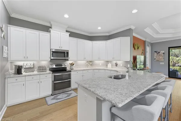 a kitchen with stainless steel appliances granite countertop a sink refrigerator and cabinets