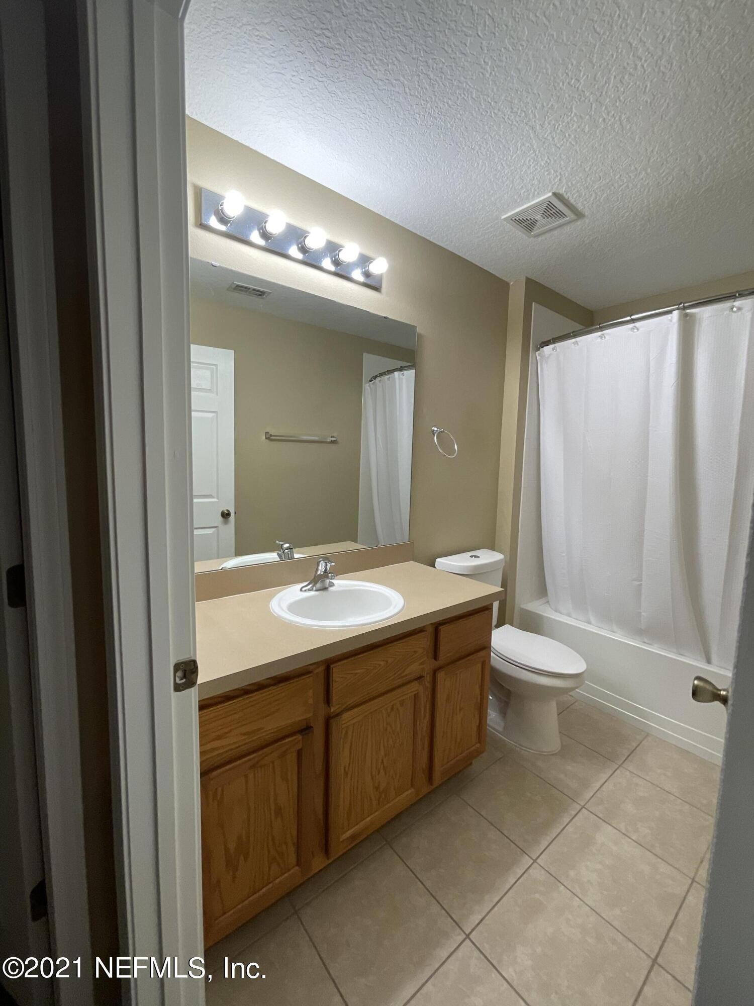 2200 Marsh Hawk Lane, Unit 101 Fleming Island, FL 32003 - Photo 12 of 18 a bathroom with a double vanity sink and a mirror