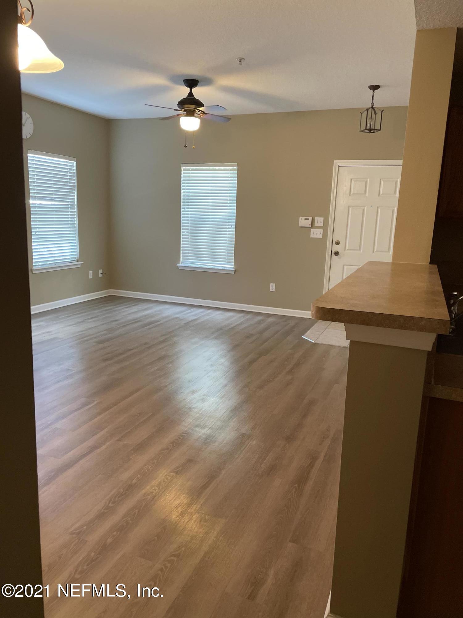 2200 Marsh Hawk Lane, Unit 101 Fleming Island, FL 32003 - Photo 15 of 18 an empty room with wooden floor and windows