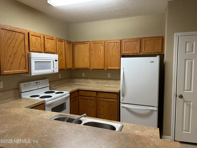 a room with furniture a window and stainless steel appliances