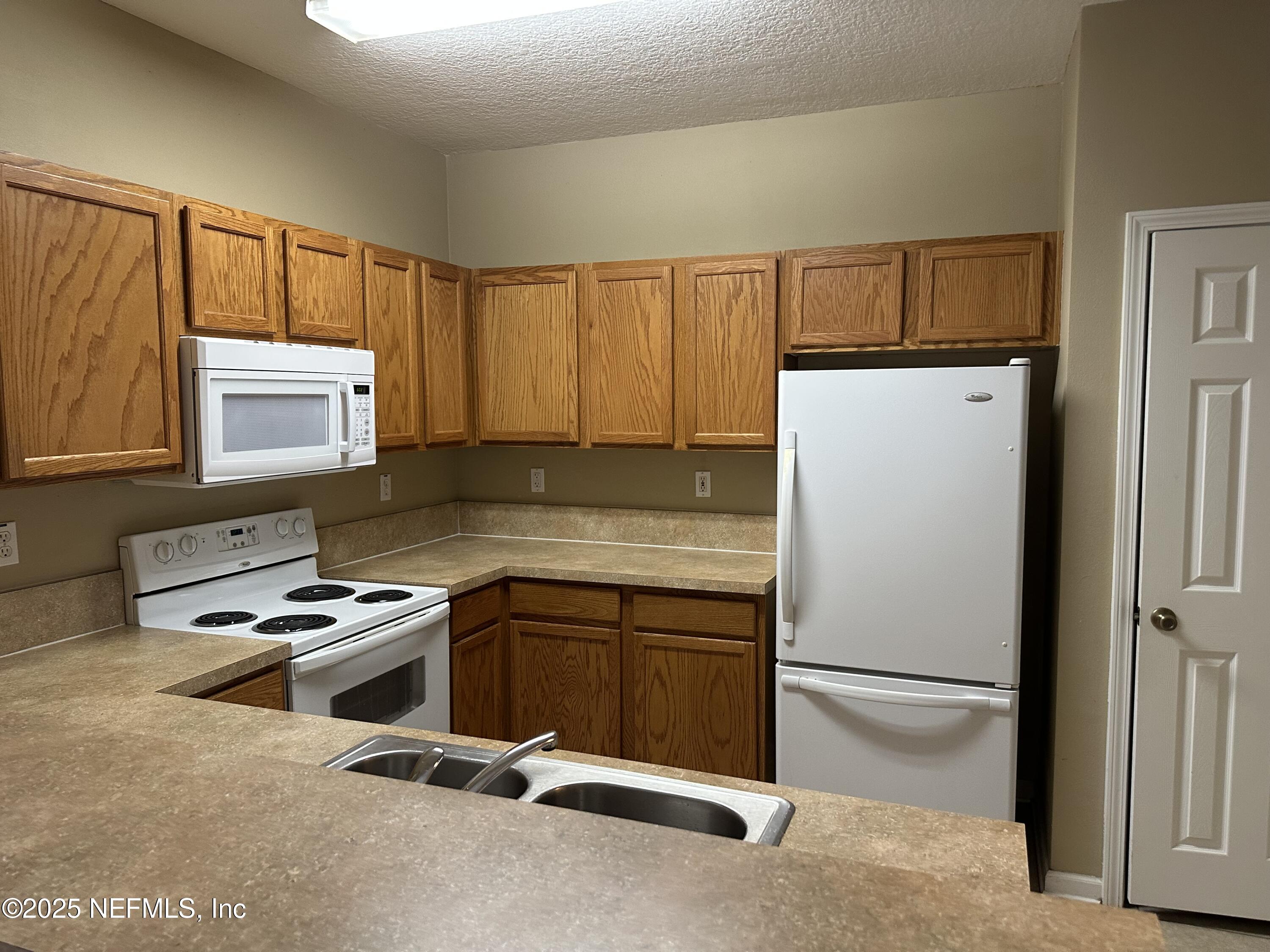 2200 Marsh Hawk Lane, Unit 101 Fleming Island, FL 32003 - Photo 16 of 18 a room with furniture a window and stainless steel appliances