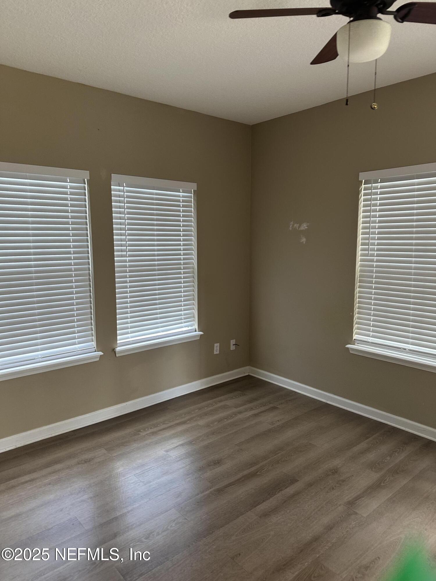 2200 Marsh Hawk Lane, Unit 101 Fleming Island, FL 32003 - Photo 17 of 18 a view of an empty room with wooden floor and a window