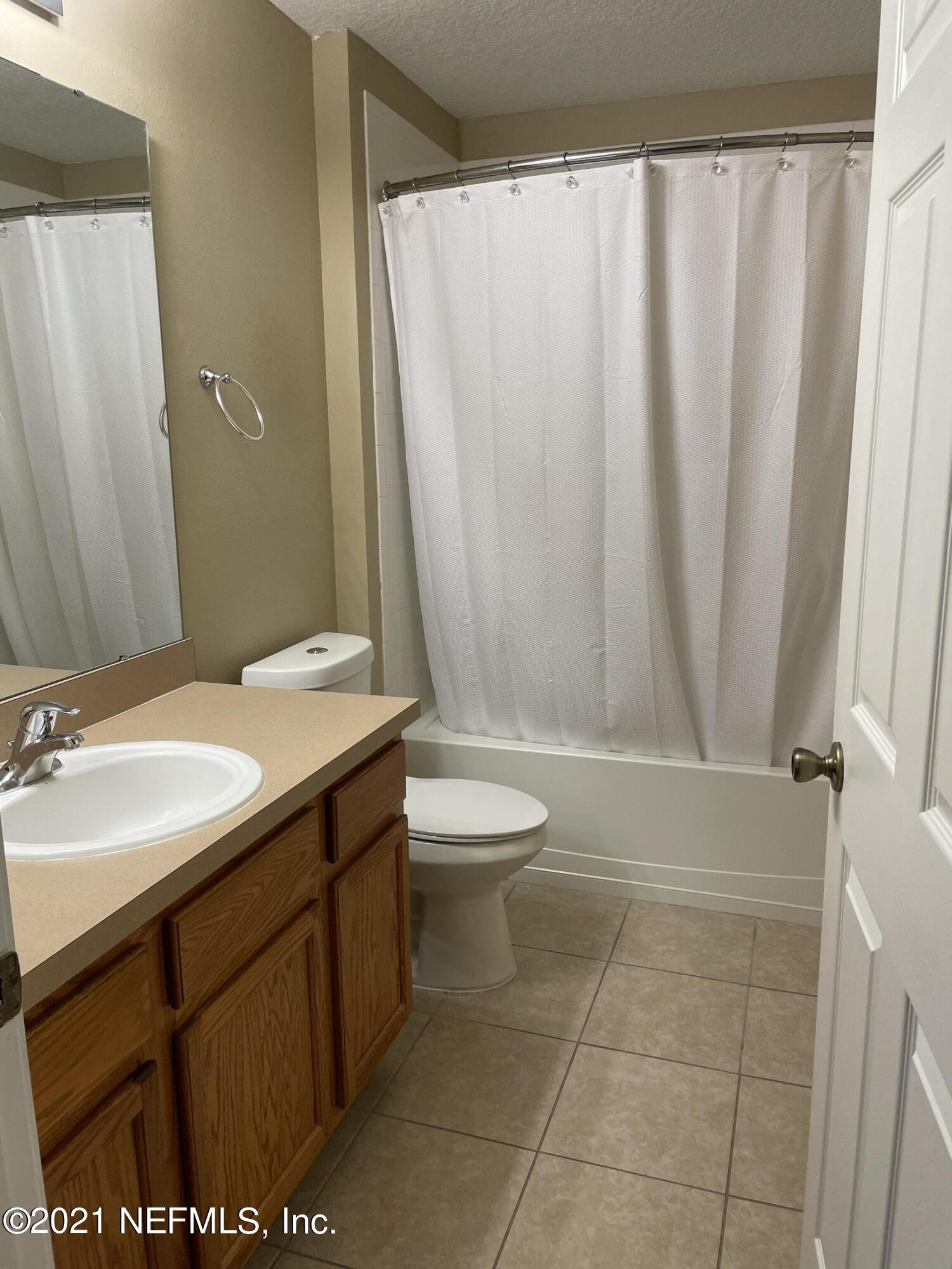 2200 Marsh Hawk Lane, Unit 101 Fleming Island, FL 32003 - Photo 7 of 18 a bathroom with a granite countertop sink toilet and shower