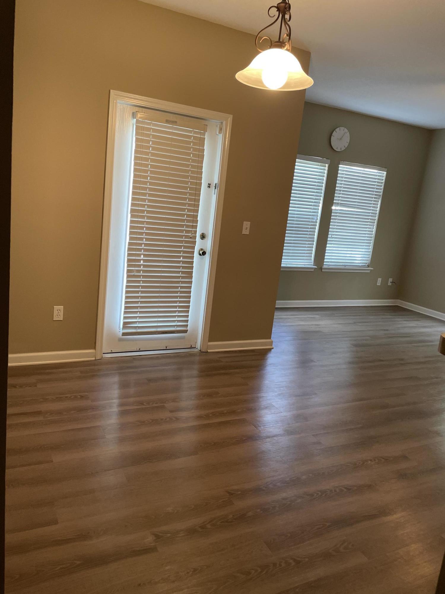 2200 Marsh Hawk Lane, Unit 101 Fleming Island, FL 32003 - Photo 9 of 18 a view of an empty room with wooden floor and a window
