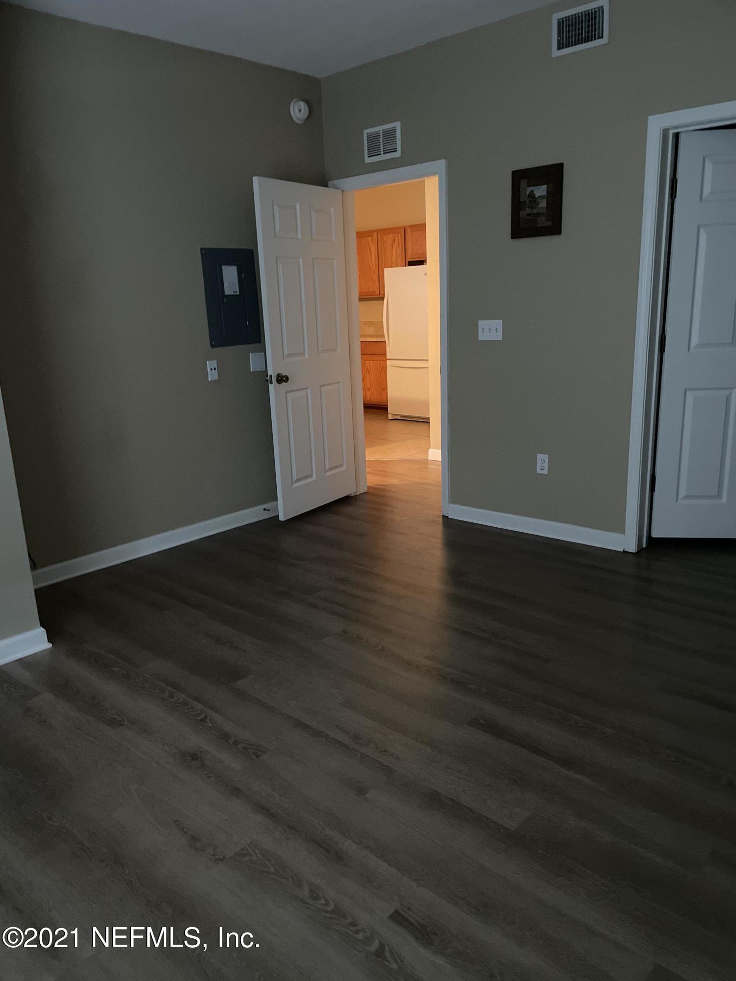 2200 Marsh Hawk Lane, Unit 101 Fleming Island, FL 32003 - Photo 10 of 18 an empty room with wooden floor and windows
