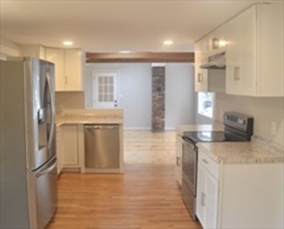 198 Cedar Street Hanover, MA 02339 - Photo 3 of 12 a kitchen with stainless steel appliances granite countertop a refrigerator a stove and a sink with wooden floor