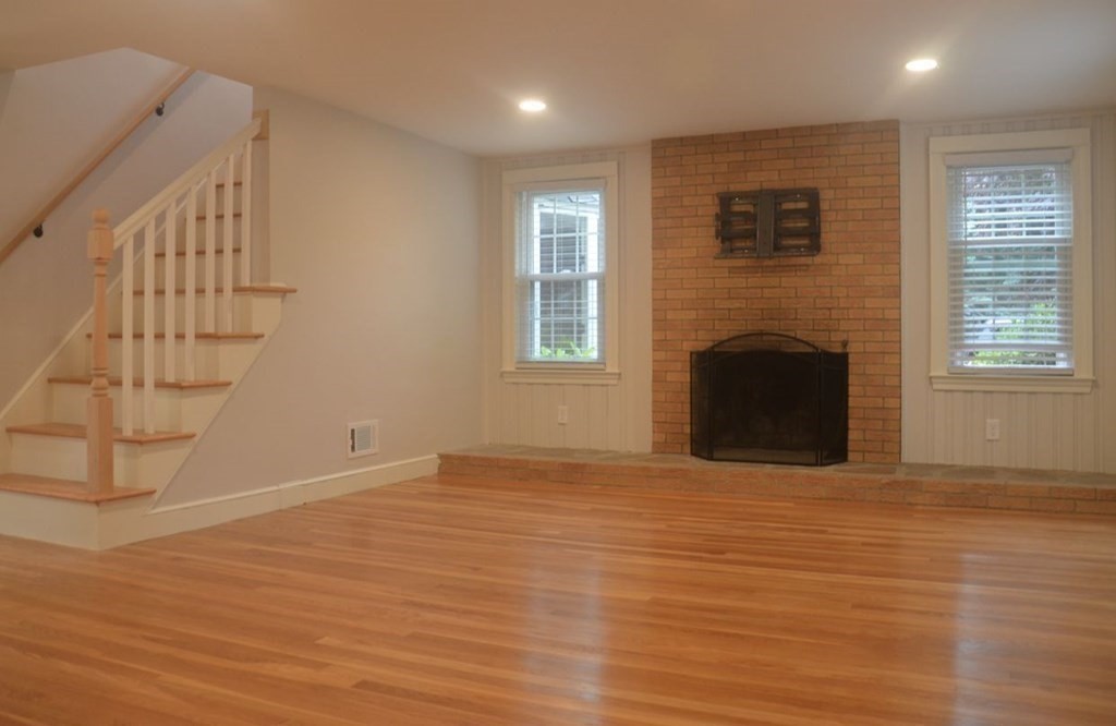 198 Cedar Street Hanover, MA 02339 - Photo 5 of 12 a view of empty room with fireplace and wooden floor