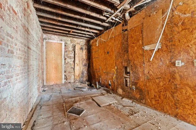 a view of an empty room with wooden floor and windows