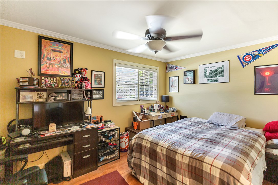 209 Calhoun Street Clemson, SC 29631 - Photo 18 of 25 Warm wood flooring and detailed crown molding enrich this comfortable bedroom.