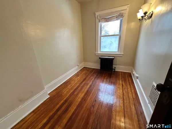 wooden floor in an empty room with a window