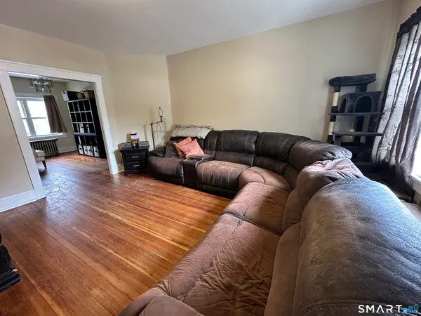 a living room with furniture and a wooden floor