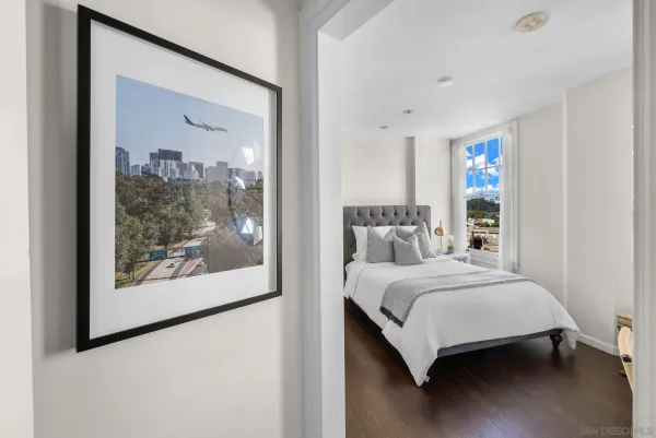 a bedroom with a bed a chandelier and a mirror