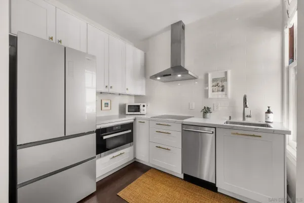a kitchen with white cabinets and white appliances
