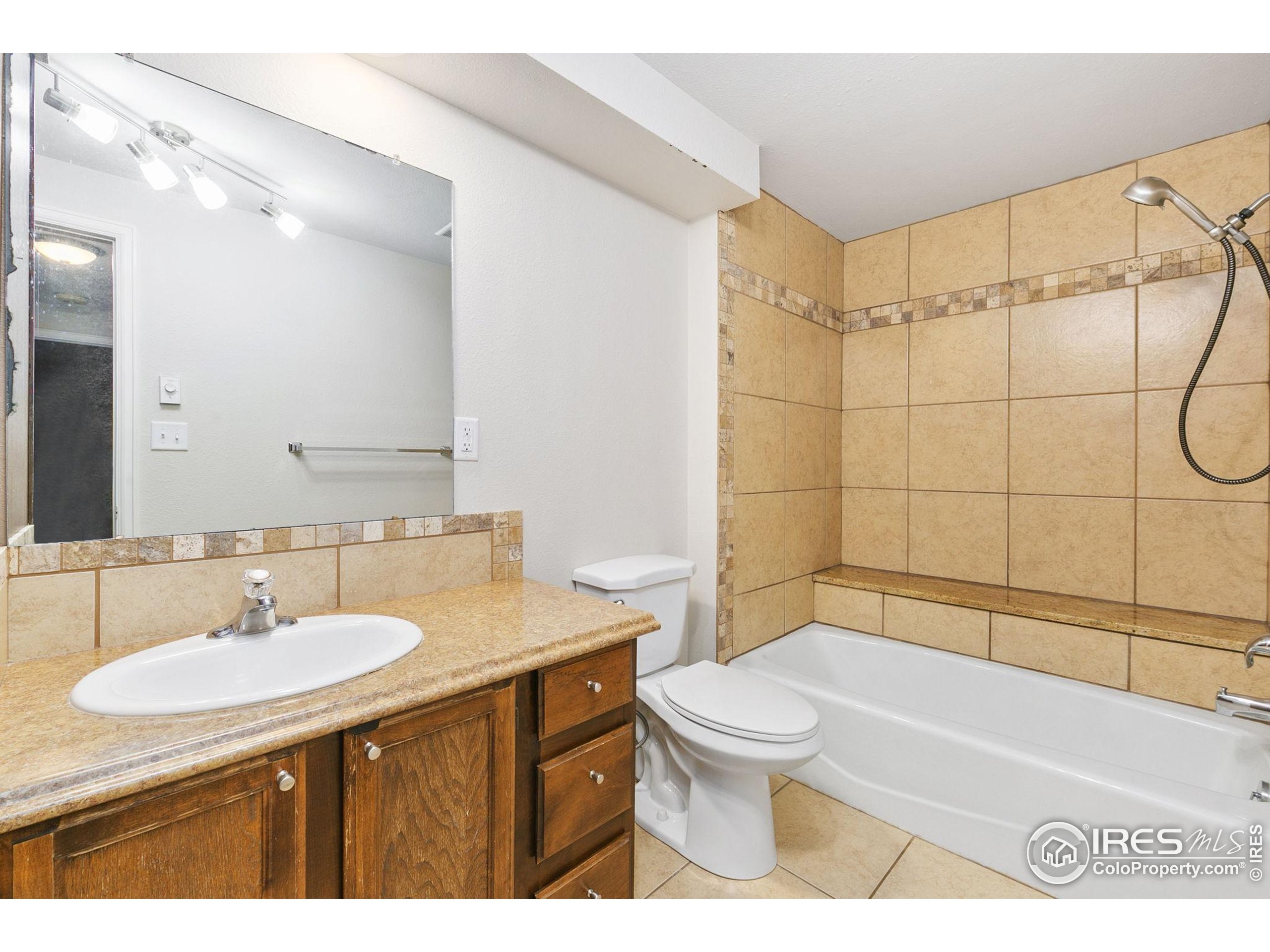 1741 Brookhaven Circle East, Unit D Fort Collins, CO 80525 - Photo 26 of 30 a bathroom with a sink toilet a mirror and shower
