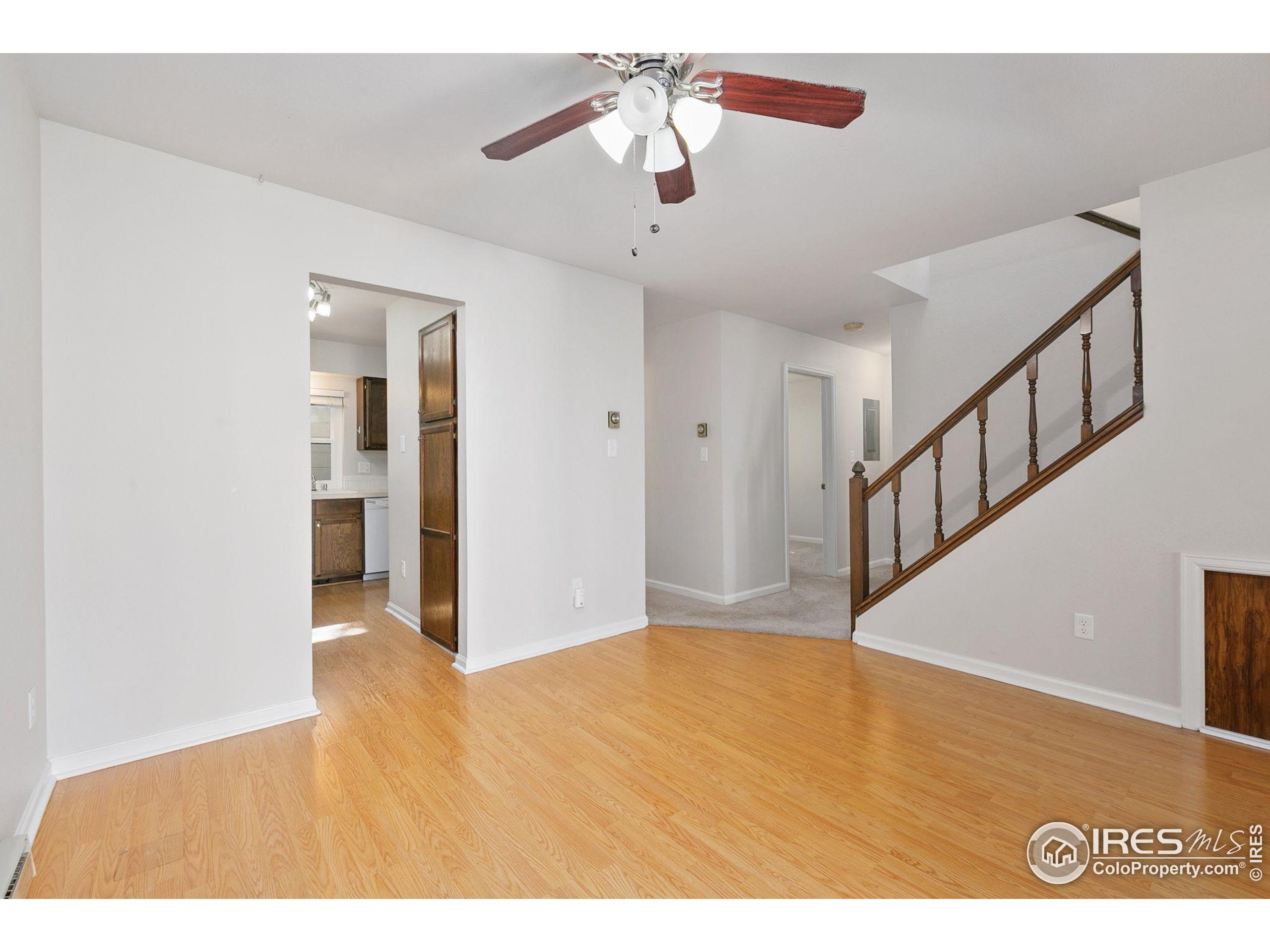 1741 Brookhaven Circle East, Unit D Fort Collins, CO 80525 - Photo 5 of 30 a view of an empty room with chandelier fan and wooden floor