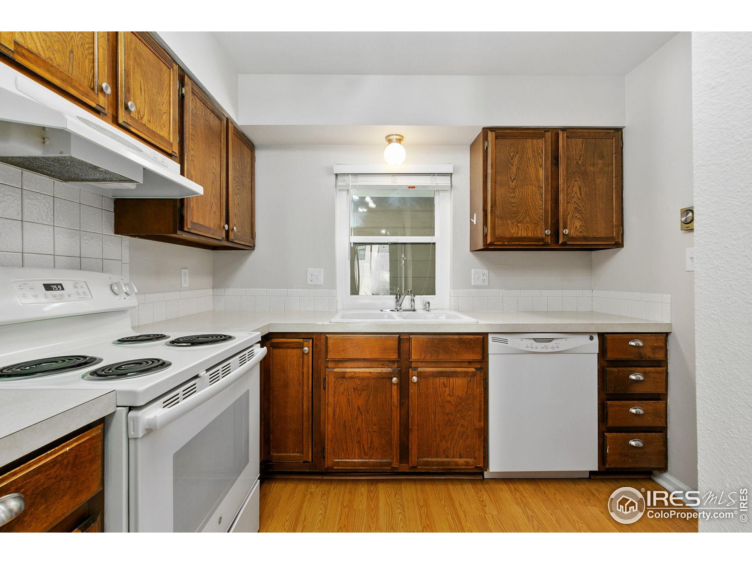 1741 Brookhaven Circle East, Unit D Fort Collins, CO 80525 - Photo 6 of 30 a kitchen with stainless steel appliances granite countertop a stove a sink and a microwave