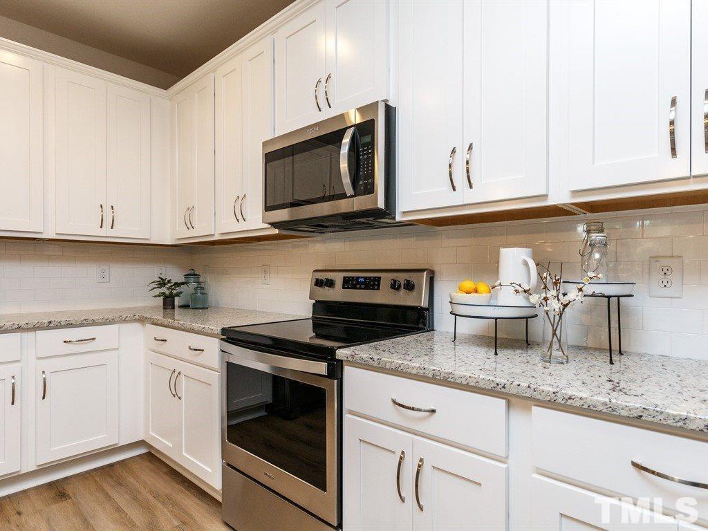3340 Tracer Drive Graham, NC 27253 - Photo 3 of 23 a kitchen with granite countertop white cabinets and a stove a oven with white countertops