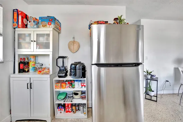 a utility room with lots of clutter and cabinets
